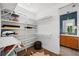 Spacious walk-in closet with white shelving and access to a bright, modern bathroom at 2803 W Aquilla St, Tampa, FL 33629