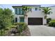 Modern two-story home with lush landscaping and a brick paver driveway at 2803 W Aquilla St, Tampa, FL 33629