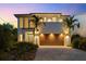 Contemporary two-story home featuring a statement wood garage door, manicured landscaping, and modern architectural details at 2803 W Aquilla St, Tampa, FL 33629
