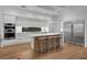 Modern kitchen featuring stainless steel appliances, sleek white cabinets, and a spacious island with bar seating at 2803 W Aquilla St, Tampa, FL 33629