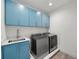 Laundry room with modern blue cabinets and appliances at 2803 W Aquilla St, Tampa, FL 33629