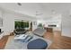 Open-concept living room features modern furnishings, hardwood floors, and seamless indoor-outdoor flow to the pool at 2803 W Aquilla St, Tampa, FL 33629