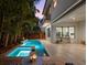 Backyard features a modern pool and spa, surrounded by lush landscaping, perfect for outdoor entertaining at 2803 W Aquilla St, Tampa, FL 33629