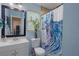 This bathroom has a modern white sink, a decorative shower curtain and a large mirror to create a warm and stylish design at 3243 Azalea Dr, Hernando Beach, FL 34607