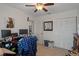 Bedroom with neutral walls, tiled floor, a ceiling fan, closet storage, and an organized desk perfect for a practical and cozy retreat at 3243 Azalea Dr, Hernando Beach, FL 34607