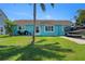 Charming home with a vibrant blue exterior, well-maintained lawn, boat on the driveway, and a palm tree at 3243 Azalea Dr, Hernando Beach, FL 34607