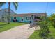 Attractive home with turquoise siding, a well-kept lawn, a boat in the driveway, and lush landscaping at 3243 Azalea Dr, Hernando Beach, FL 34607