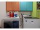 Efficient laundry area with vibrant cabinets, a washer, and a dryer for convenient chores at 3243 Azalea Dr, Hernando Beach, FL 34607