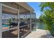 A view of the pool area with brick flooring, multiple grills, boat dock, and waterfront views at 3243 Azalea Dr, Hernando Beach, FL 34607