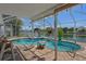 Lakeside pool area features a serene pool, a relaxing hot tub, a screened lanai, and lush landscaping for luxurious outdoor enjoyment at 3243 Azalea Dr, Hernando Beach, FL 34607