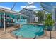 This backyard features a screened pool area, a tranquil pool, a convenient hot tub, and a charming patio for ultimate relaxation at 3243 Azalea Dr, Hernando Beach, FL 34607