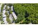 Aerial view displays homes nestled by a forest with lush landscapes, a road, and some parking areas at 3350 Fox Hunt Dr, Palm Harbor, FL 34683