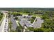 An aerial view shows the property and surrounding landscape with mature trees, green spaces, and a nearby road at 3350 Fox Hunt Dr, Palm Harbor, FL 34683