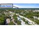 Scenic aerial view displays Lake Tarpon in the distance behind a community and features lush landscapes and paved roads at 3350 Fox Hunt Dr, Palm Harbor, FL 34683