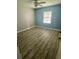 This bedroom has wood flooring, a window, and paint on the walls at 34645 Camphor N Dr, Pinellas Park, FL 33781