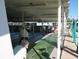 Residents enjoying a shuffleboard game in the covered courts at 34645 Camphor N Dr, Pinellas Park, FL 33781
