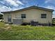 Side view of the home showcasing the fenced backyard, exterior door, two windows and AC Unit at 35020 Colony Hills Dr, Zephyrhills, FL 33541