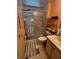 Bathroom featuring a shower with glass doors, peach walls, and vanity storage at 35020 Colony Hills Dr, Zephyrhills, FL 33541