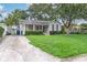 Cozy home with green lawn and driveway, surrounded by mature trees and lush landscaping at 3503 W Palmira Ave, Tampa, FL 33629