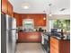 Well-lit kitchen with granite counters, stainless steel appliances, custom cabinets and terrazzo flooring at 3622 W Mullen Ave, Tampa, FL 33609