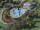 Aerial view of luxurious pool area with many chairs, palm trees, and clubhouse at a new community at 3655 Moscato Dr, Brooksville, FL 34602