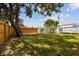 Spacious backyard with a wooden fence and a large tree offering plenty of shade at 3850 Carioca Rd, Holiday, FL 34691