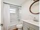 Well-lit bathroom features a shower over the tub, a modern vanity, and stylish marble tile at 3850 Carioca Rd, Holiday, FL 34691