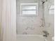 Elegant bathroom showcasing a shower over the tub with marble tile surround at 3850 Carioca Rd, Holiday, FL 34691