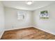 Bright bedroom features hardwood floors, crisp white trim, and sunlit windows at 3850 Carioca Rd, Holiday, FL 34691