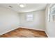 Bedroom featuring hardwood floors, white trim, and two sunlit windows at 3850 Carioca Rd, Holiday, FL 34691