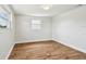 Bright bedroom features hardwood floors, crisp white trim, and a sunlit window at 3850 Carioca Rd, Holiday, FL 34691