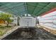 Carport with an attached storage shed and view of the surrounding greenery at 3850 Carioca Rd, Holiday, FL 34691