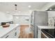 Open concept kitchen features an island with seating and stainless steel refrigerator at 3850 Carioca Rd, Holiday, FL 34691