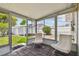 Relaxing sunroom with brick flooring, comfortable seating, and bright views of the outdoor space at 3850 Carioca Rd, Holiday, FL 34691
