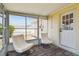 Enclosed sunroom with tiled floor, white chairs, and a bright view of the outside at 3850 Carioca Rd, Holiday, FL 34691