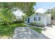 Charming single-story home with a blue front door, landscaped yard, and a concrete driveway at 4044 56Th N Ave, St Petersburg, FL 33714