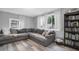 Inviting living room featuring wood floors, a comfortable gray sectional, and natural light from large windows at 4044 56Th N Ave, St Petersburg, FL 33714