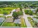 Aerial view of houses surrounded by lush trees and green spaces with neighborhood streets at 4108 Woodtrail Blvd, New Port Richey, FL 34653
