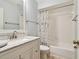 Well-lit bathroom featuring a marble countertop, stylish vanity, and a shower-tub combination with white tile at 4108 Woodtrail Blvd, New Port Richey, FL 34653