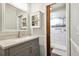 Bathroom featuring a vanity, wall cabinet, and a shower with white and gray tiled walls at 4108 Woodtrail Blvd, New Port Richey, FL 34653