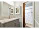 Bathroom featuring a vanity, wall cabinet, and an open view of the shower with patterned shower curtain at 4108 Woodtrail Blvd, New Port Richey, FL 34653