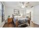 Cozy bedroom featuring a wrought iron bed frame, wood floors, and an attached bathroom at 4108 Woodtrail Blvd, New Port Richey, FL 34653