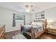 Comfortable bedroom featuring wood floors, ceiling fan and natural light at 4108 Woodtrail Blvd, New Port Richey, FL 34653