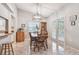 Dining room with a wooden table set beneath a modern light fixture and backyard access at 4108 Woodtrail Blvd, New Port Richey, FL 34653