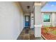 Inviting front porch with slate flooring and a charming blue front door at 4108 Woodtrail Blvd, New Port Richey, FL 34653