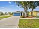 Beautifully landscaped front yard featuring a charming home with a blue garage door at 4108 Woodtrail Blvd, New Port Richey, FL 34653