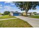 Inviting home exterior with a well-manicured lawn and a blue garage door at 4108 Woodtrail Blvd, New Port Richey, FL 34653