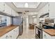 Open kitchen featuring stainless steel appliances, white cabinetry and adjacent dining area at 4108 Woodtrail Blvd, New Port Richey, FL 34653
