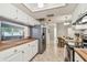 Kitchen with stainless steel appliances, white cabinetry and eat in dining space at 4108 Woodtrail Blvd, New Port Richey, FL 34653