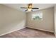 An empty carpeted bedroom showcasing the room's window, ceiling fan, and electrical outlets at 4207 Northwind Ln, Tampa, FL 33624
